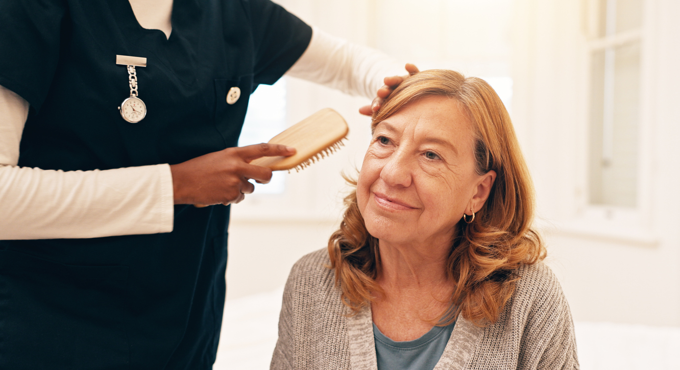 Brush, help and nurse with woman for hair in retirement home for healthcare consultation. Happy, assisting and caregiver with senior patient for hairstyle getting ready in morning at nursing facility