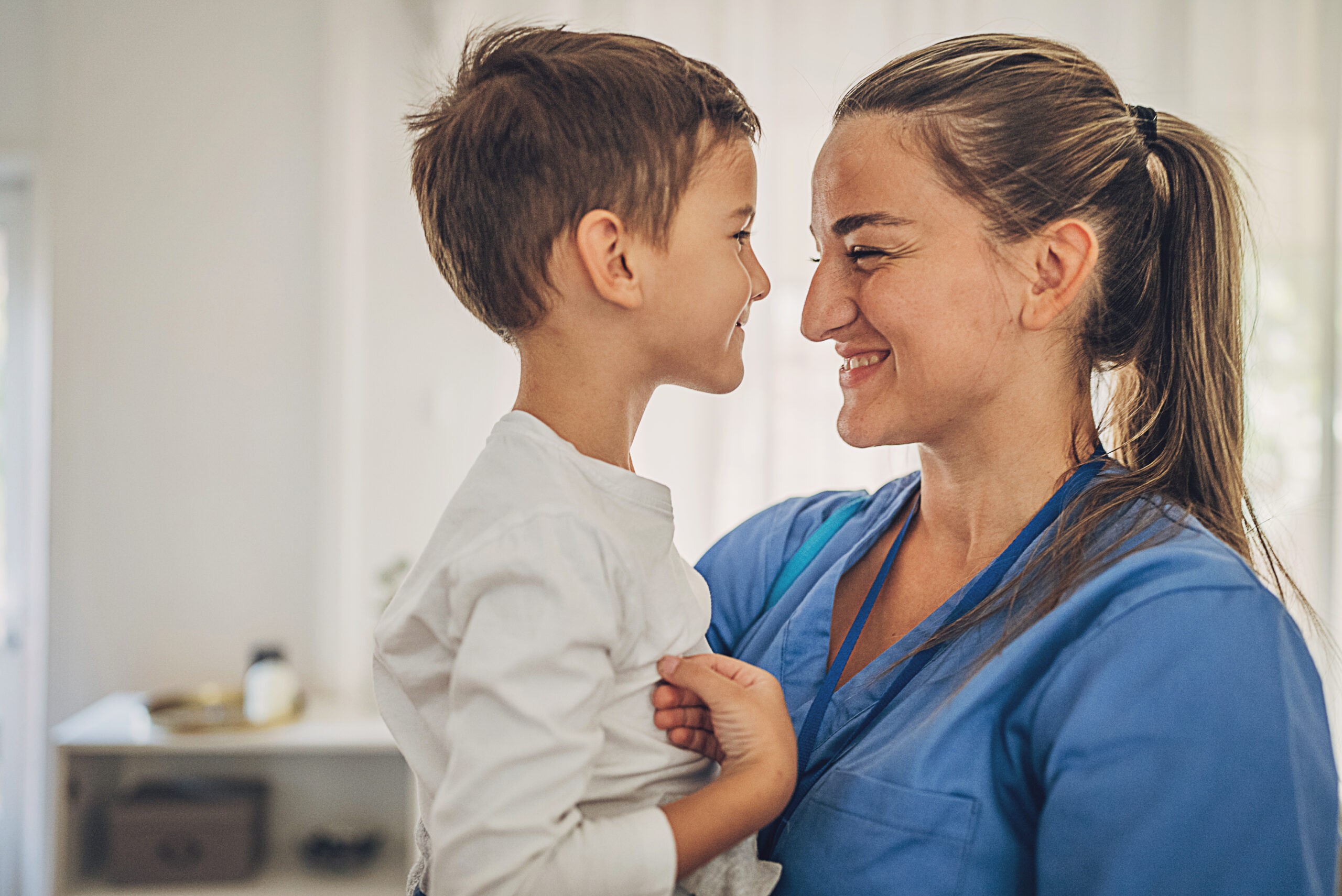 Female nurse hugging with her son at home after work